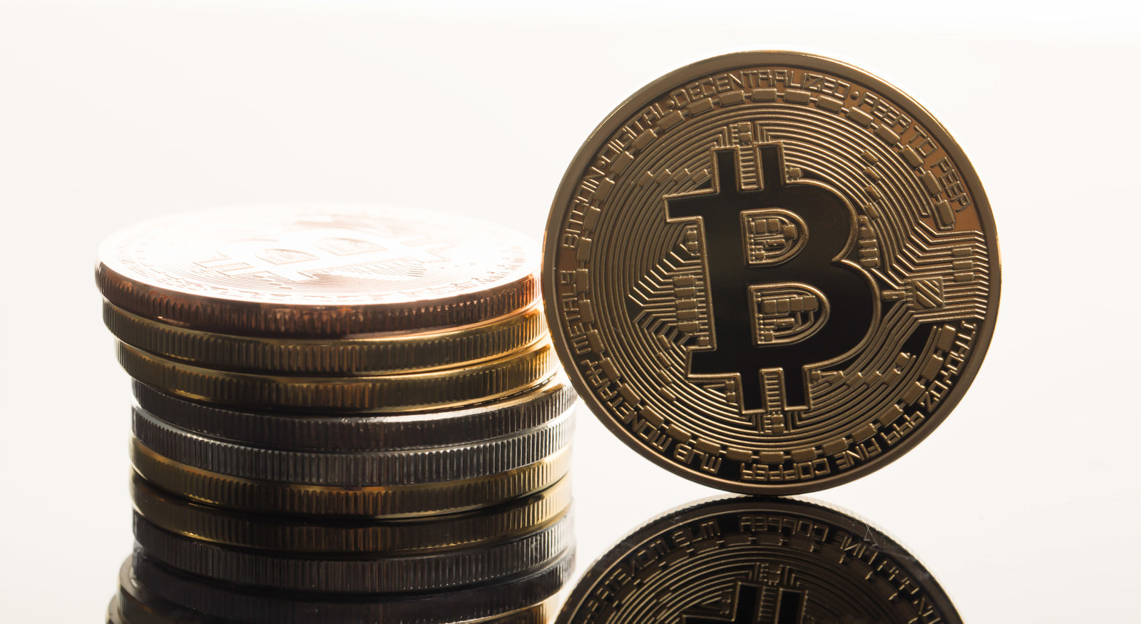 積み重ねた硬貨とビットコイン