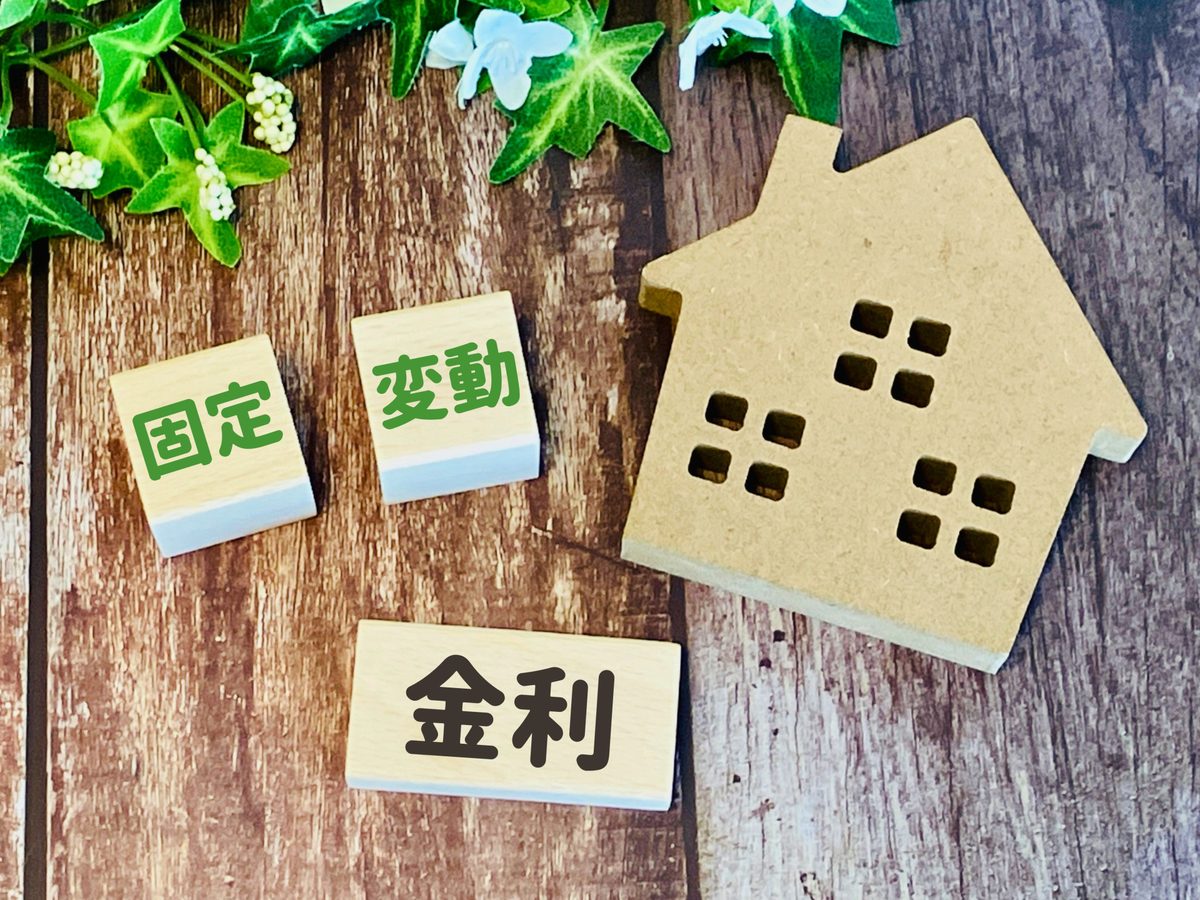 木の家の模型と「固定」「変動」「金利」と書かれた積み木