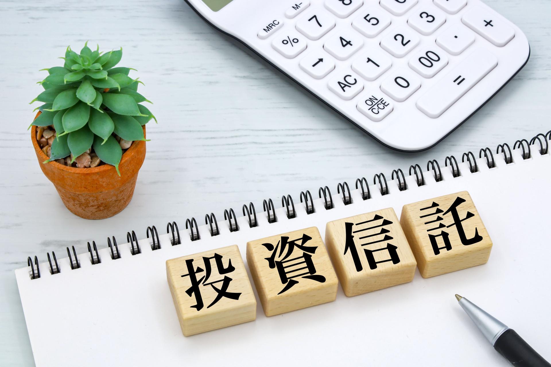 投資信託と書かれた積み木と電卓