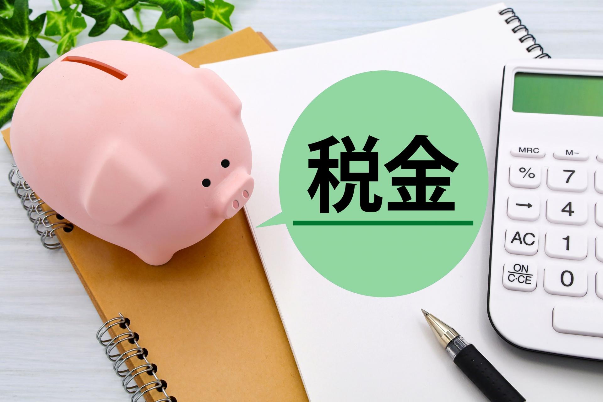 税金と書かれた札と豚の貯金箱